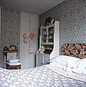 Blau-weißes Schlafzimmer mit Tapete im William-Morris-Stil und cremefarbener Kommode