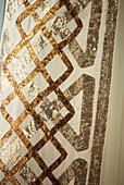 Detail of metallic ribbons on an altar cloth hanging in a window