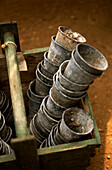 Stack of small zinc potting pots in a greenhouse