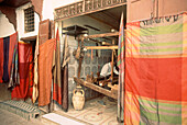 Stoffweberin bei der Arbeit in einer Werkstatt in der Medina von Fez, Marokko