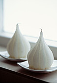 White candle in the shape of a pear on a window sill
