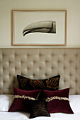 Luxurious bed with neutral decor headboard and velvet cushions