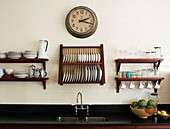 Kitchen with traditional dairy tiles granite work surface sink and wall mounted crockery storage racks