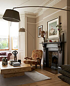 Victorian fireplace with and floor lamps in living room of in London townhouse, UK