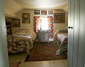 Vintage crocheted and patchwork quilts decorate the twin beds in the guest room