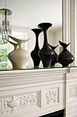 Black and white vases on shelf above fireplace