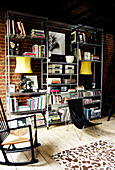 Large metal storage unit filled with books Cds and objects against an exposed brick wall in living room