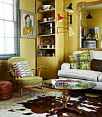 Yellow living room with cow hide rug and retro furniture and fabrics