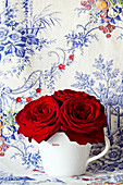 Red roses and floral patterned wallpaper
