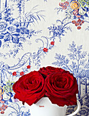 Red roses and blue floral wallpaper