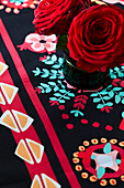 Red roses on a patterned tablecloth