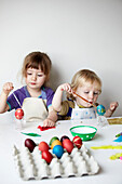 Brother and sister decorating Easter eggs