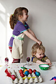 Brother and sister decorating Easter eggs