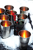 Metallic tealights on a tray in the snow