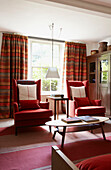 Living room with red soft furnishings and a modern country decor