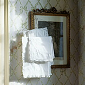 Lace pillow cases and gilt framed artwork, detail in London home, UK