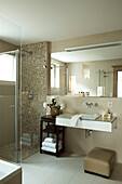 Large mirror above washbasin with shower cubicle in luxury Zermatt home, Switzerland