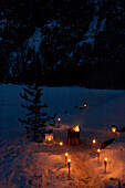 Beleuchtete Ölbrenner und Kohlenbecken im Bergschnee, Zermatt, Wallis, Schweiz