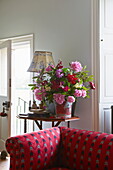 Cut flowers and upholstered sofa in Cumbrian farmhouse, England, UK