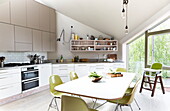 Dining room table with lime green chairs in contemporary open plan London kitchen, England, UK