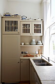 Cream cupboards and double sink in kitchen of London townhouse, England, UK