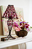 Vintage lamp and flowers on mantlepiece in London townhouse, England, UK