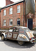 Vintage car outside brick Evershot home, Dorset, kent, UK