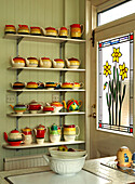 Stained glass daffodils with teapot collection at back door of London home, England, UK