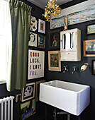 Vintage cabinet and artwork above sink at window in family home, Rye, East Sussex, England, UK