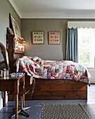 Patchwork quilt on wooden double bed with lit fairylights in Rye family home, East Sussex, England, UK