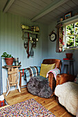 Brauner Ledersessel mit Fellüberwurf in getäfeltem Sommerhaus in Rye, East Sussex, England, Vereinigtes Königreich