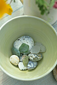 Close up of seaside pebbles in pottery bowl