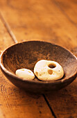 White pebbles in wooden bowl on tabletop