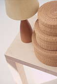 Stilleben aus Seegrasstapelkörben Holztischlampe auf hellem Holzbeistelltisch