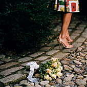 Woman walking away from bouquay of flowers on the ground