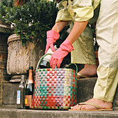 Young woman putting out bottles for recycling