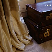 Suitcase on floor next to silk curtains
