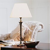 Cremelampe mit gehämmertem Metallsockel auf Beistelltisch in Zimmer mit Chaiselongue