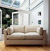 Angled cream sofa angled in conservatory extension