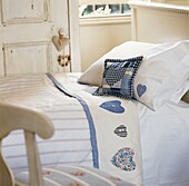 Patchwork-Kissen auf einem Einzelbett in einem Strandhaus