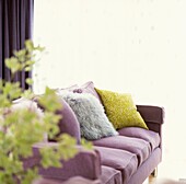 Fliederfarbenes Sofa mit Kissen und Kopierrahmen