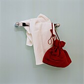 Rote Tasche und weißes Handtuch hängen an der Badezimmerwand