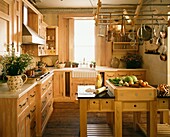 Wooden kitchen with metal rack for utensils above chopping board on butcher's block
