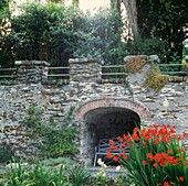 Arched seating area under stone bridge