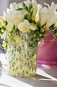 Glass vase with arrangement of yellow freesias