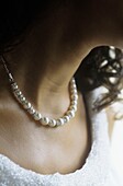 Close up of pearls on a woman's neck