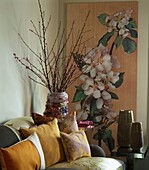 Room corner with floral blossom canvas and sofa filled with cushions