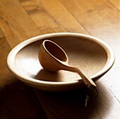 Wooden bowl and spoon on wooden floor