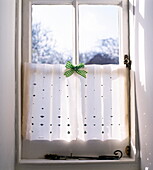 Paper cut window shade with green gingham bow