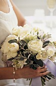 Bride holding wedding bouquet of white flowers and silver green Stachys 